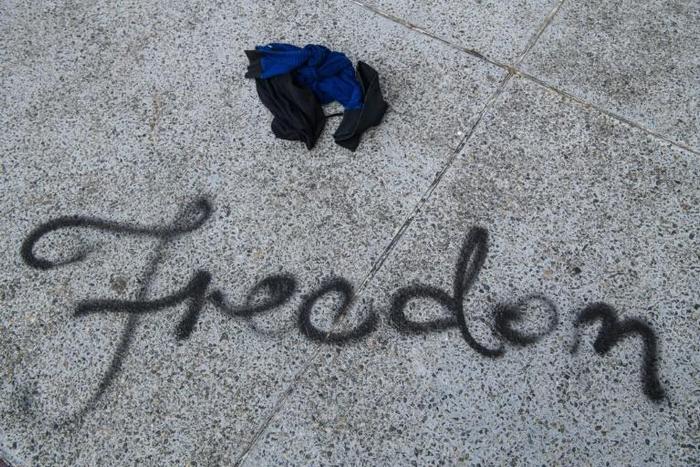 The English word "freedom" was spray-painted in cursive letters on a walkway