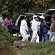 A team of forensic experts work in the site where seven bodies were found inside three abandoned vehicles