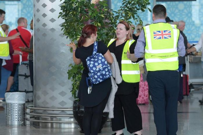 British officials talk to tourists booked with Thomas Cook as they wait for repatriation flights from Enfidha airport on the outskirts of the Tunisian coastal resort of Sousse