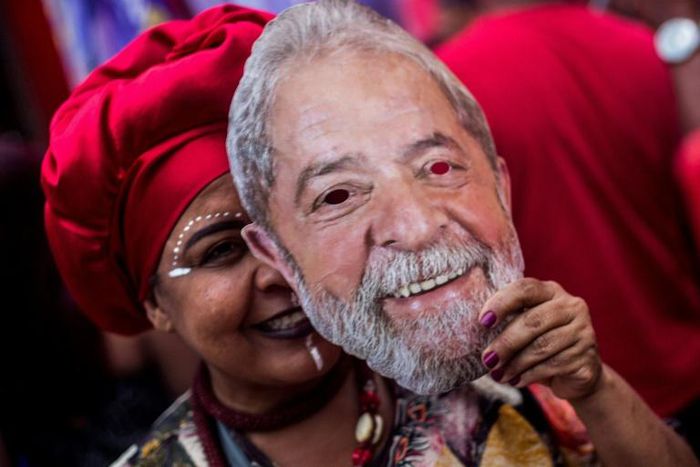 A supporter of Brazil's Workers Party holds a mask with the face of imprisoned former Brazilian president Luiz Inacio Lula da Silva