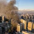 Smoke billows from a building on fire near where protesters were demonstrating in Santiago, on October 28, 2019
