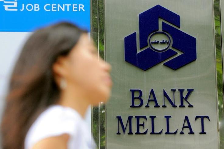 Iran has claimed a "victory" after one of its banks received compensation from British authorities over "illegal" sanctions; in a file picture taken on September 8, 2010 a woman walks past a signboard of Bank Mellat, an Iranian state-run commercial ban...