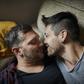 Affectionate gay couple resting on couch at home