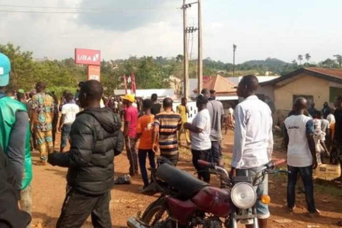 Residents of the community gather around the bank after the robbery incident. (TheCable)