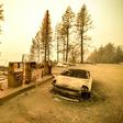 A burnt car and a gas station remain visible on November 11, 2018 after the "Camp" fire tore through the region near Pulga, east of Paradise, California