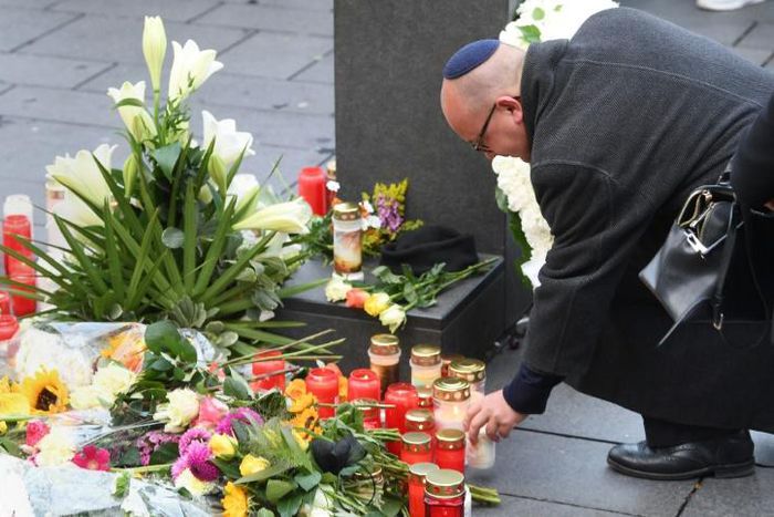 A man wearing a kippah skullcap places a candle at a makeshift memorial a day after two people were shot dead as Halle's Jewish community marked Yom Kippur