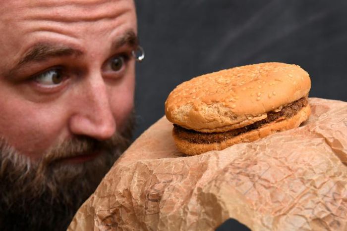 Casey Dean inspects a McDonald's burger he bought in 1995 with friend Eduards Nits and kept in an Australian shed for years