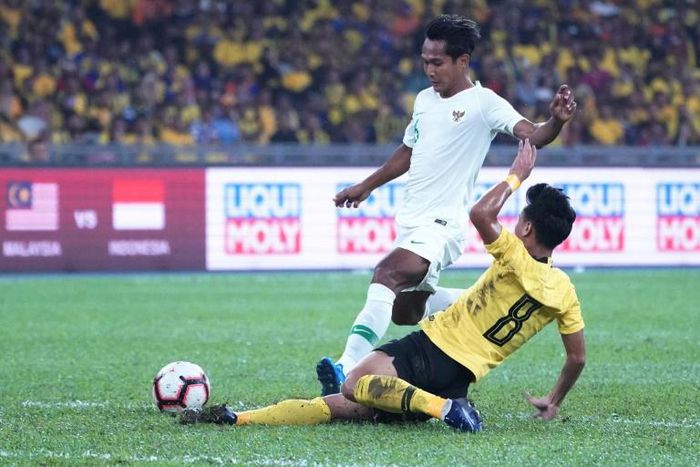 Malaysia's Muhamad Nor Azam  tries to escape a tackle from Indonesia's Hendro Siswanto in  as the home team win Kuala Lumpur