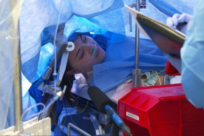 In this October 29, 2019, still image taken from a video courtesy of Methodist Dallas Medical Center in Dallas, Texas, Jenna Schardt, 25, remains conscious while neurosurgeons perform brain surgery