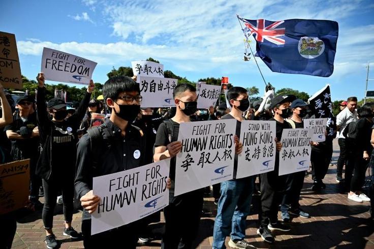Supporters of the Hong Kong pro-democracy protesters hold placards during a demonstration as part of the global "anti-totalitarianism" movement in Sydney