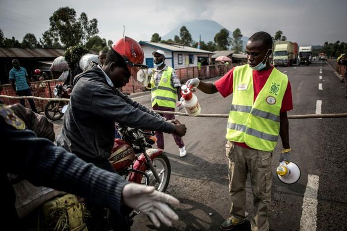 A motor taxi driver gets his hands washed at an Ebola screening station in eastern DR Congo
