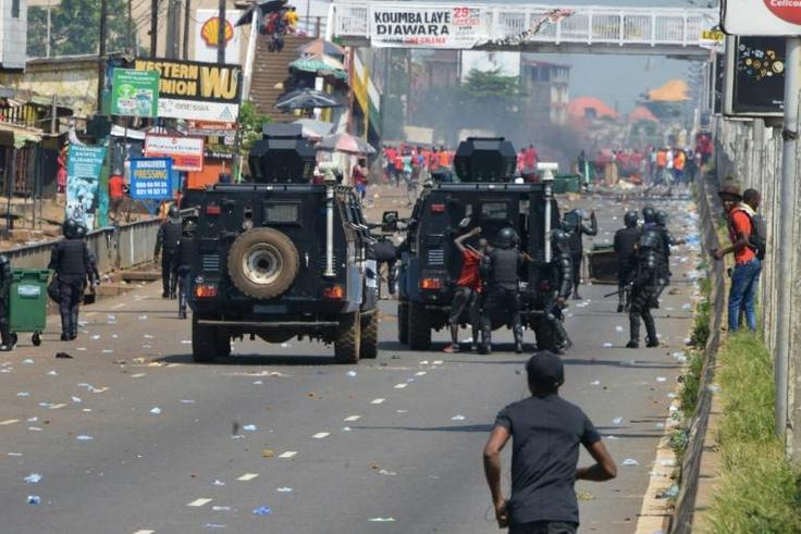 Police officers arrest a man during a protest against the third term of the Guinean President in Conakry, on November 14, 2019