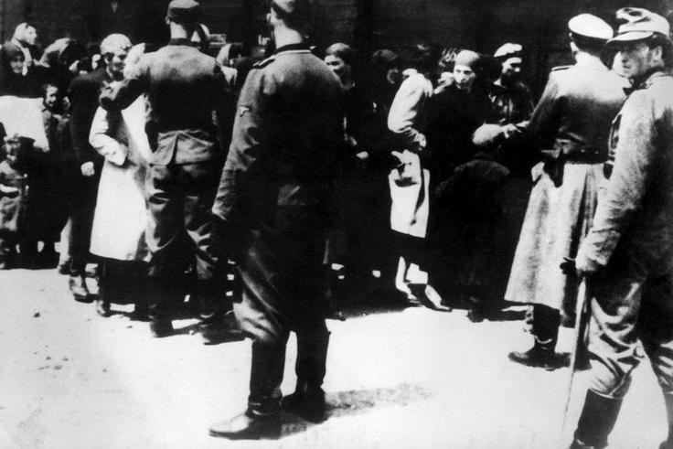 SS soldiers lead newly arrived prisoners to the gas chambers at the Auschwitz concentration camp. The death camp remains an enduring symbol of the Holocaust.
