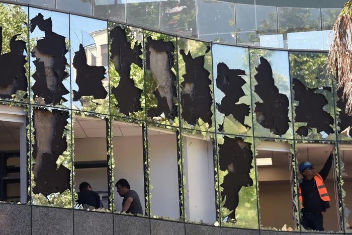 Workers repair damage to the offices of a pension fund after violent protests in Chile spread to the upmarket Santiago neighborhood of Providencia