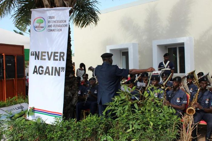 This picture shows a banner reading "Never Again" is seen as a police band performs during the Truth and Reconciliation and Reparation Commission, at the Dune's Resort, in Kotu, near Bajul, on October 15, 2018