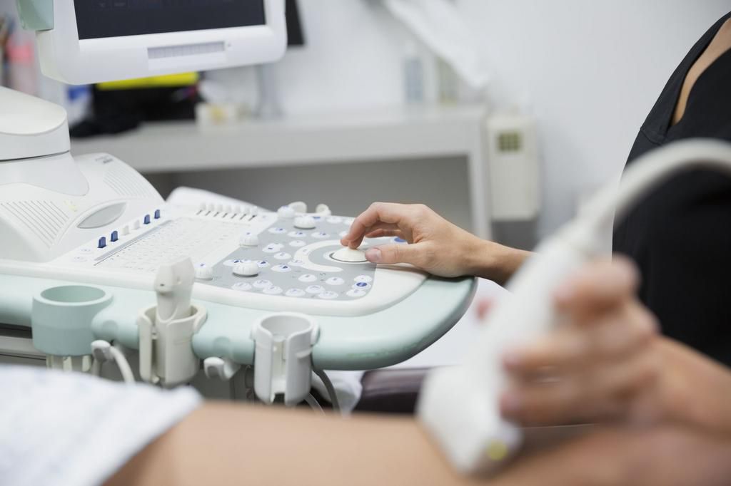 Technician treating varicose veins with ultrasound equipment