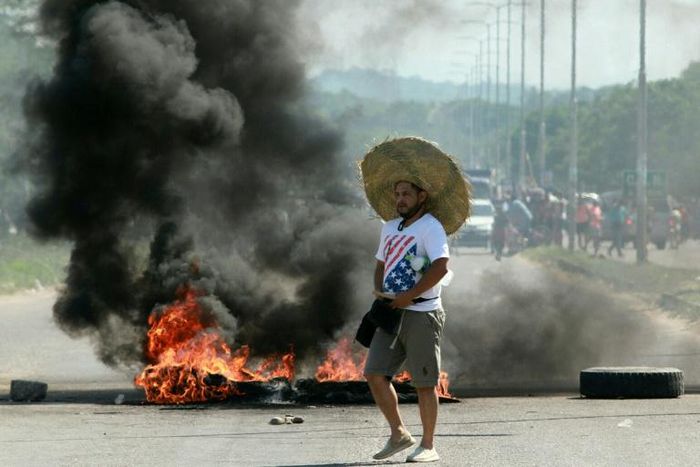 A supporter of Bolivian opposition candidate Carlos Mesa passes a burning barricade during clashes with supporters of Bolivian President Evo Morales on October 24, 2019