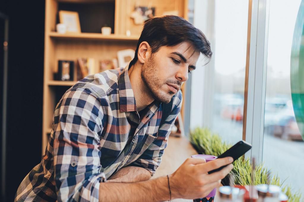 Man texting at the cafe