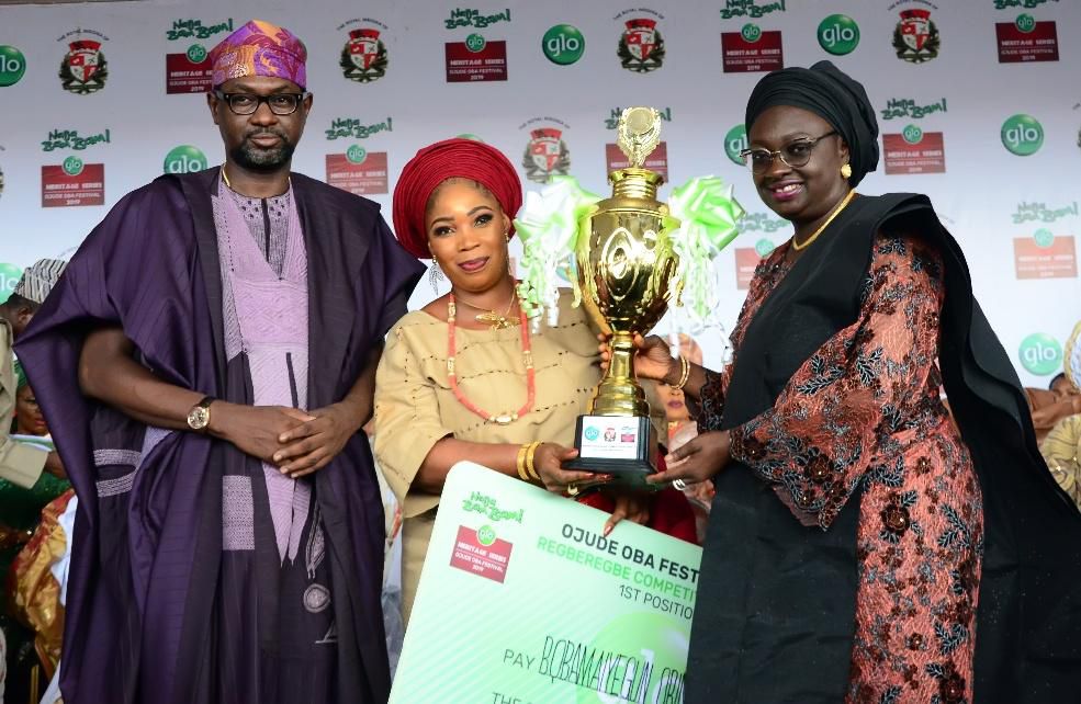 (Left to Right) Globacom Representative, Mr. Folu Aderibigbe, representative of "Bobamayegun Obirin Aremo" the winner of the Regberegbe Female Competition at this year's Ojude Oba Festival receiving the winner's trophy from the Deputy Governor of Ogun ...