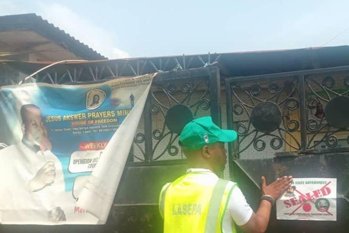 Officials of the Lagos State Environment Protection Agency (LASEPA) sealing off some religious centres and other facilities allegedly contravening the environmental law of the state. [Twitter/@LasepaInfo]