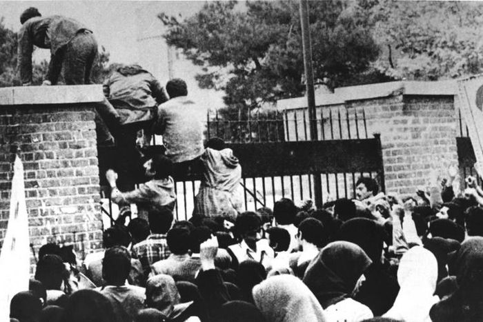 Iranian revolutionary students climb the American embassy's gate in Tehran on November 4, 1979 less than nine months after the toppling of the US-backed shah