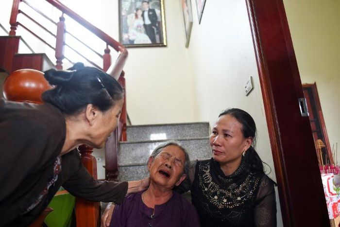 Tran Thi Hue (C), grandmother of 30-year old Le Van Ha, who is feared to be among the 39 people found dead in a truck in Britain, is consoled by relatives inside their house in Vietnam's Nghe An province