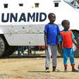 Displaced Sudanese boys pose for a picture in front of a UN-African Union mission to Darfur (UNAMID) vehicle at the Kalma camp for internally displaced people in Darfur's state capital Niyala on October 9, 2019