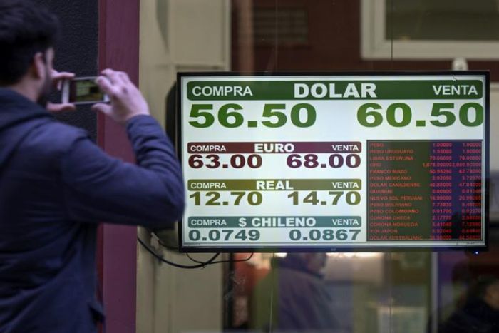 Currency exchange values are displayed on the buy-sell board of a bureau de exchange in Buenos Aires, on August 14, 2019