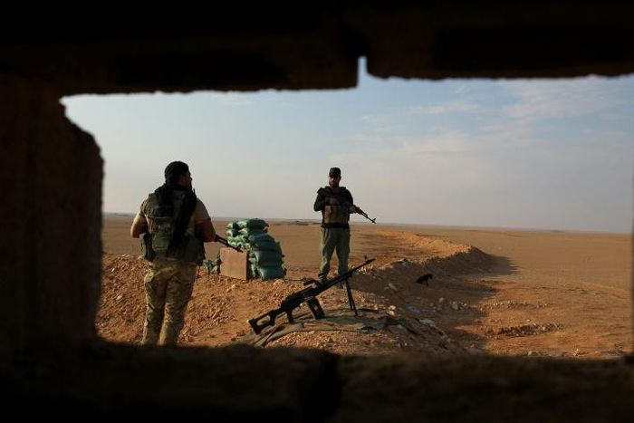 Iraqi Shiite fighters of the Hashed al-Shaabi paramilitary force secure the border area with Syria in al-Qaim in Iraq's Anbar province late last year