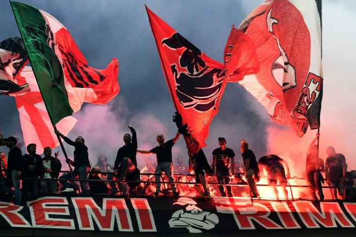 AC Milan fans wave flags during the city derby against Inter Milan in the San Siro stadium.