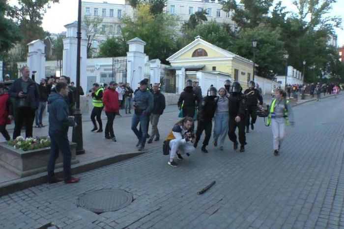 The video, which has more than 360,000 views, shows a young woman dragged by four masked policemen in riot gear, with one of them punching her in the stomach for no apparent reason  
