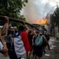 Demonstrators hold up a hose as flames engulf the Pedro de Valdivia University following a protest against the government of Chilean President Sebastian Pinera in Santiago, on November 8, 2019.Unrest began in Chile last October 18 with protests against...