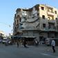 People walk near heavily damaged buildings in the rebel-held city of Idlib in northwestern Syria on September 16, 2019