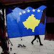A pedestrian walks behind the Kosovo flag ahead of last year's 10th-anniversary celebrations in Pristina of Kosovo's declaration of independence
