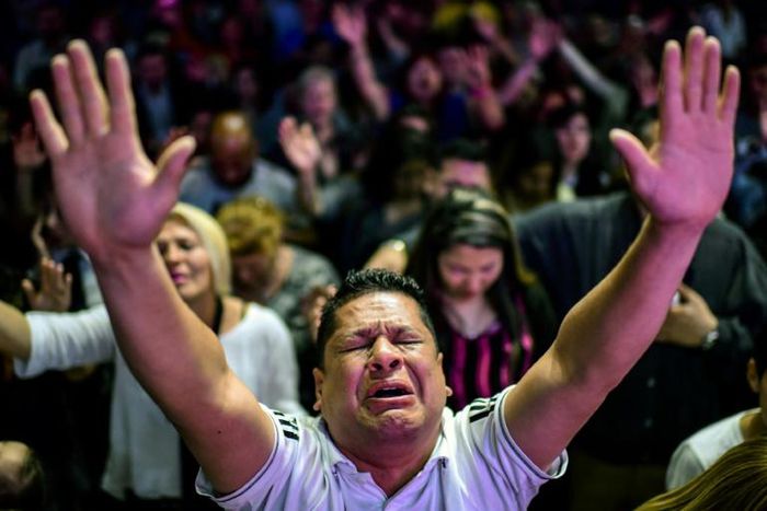 Followers participate in a religious service at the Manantial de Bendiciones Evangelical church in San Martin, Buenos Aires province