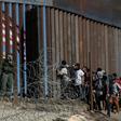 Central American migrants look through a border fence as a US Border Patrol agent stands guard near Tijuana, Mexico: people who cross the border illegally will have their DNA collected by US officials in the future