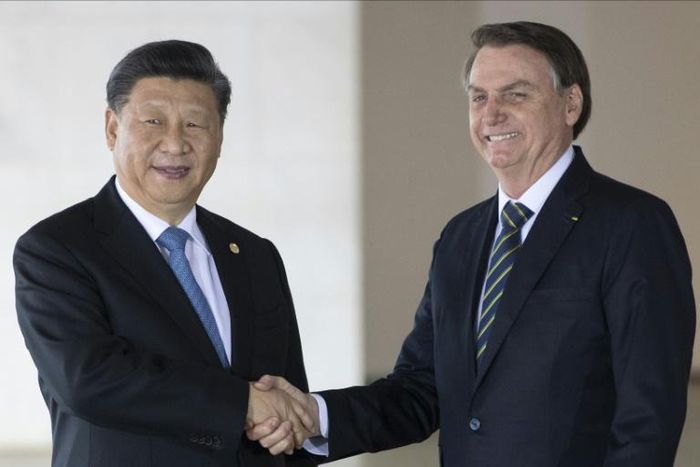 Brazil's President Jair Bolsonaro (R) and China's President Xi Jinping shake hands before the 11th BRICS Summit at the Itamaraty palace in Brasilia, Brazil