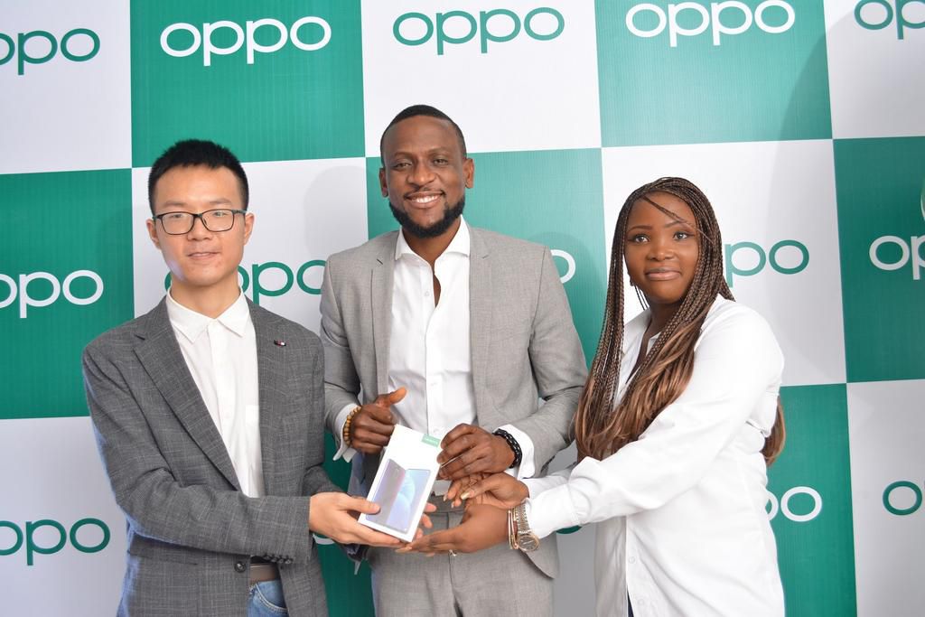 LEFT, Kris Cao, Marketing Director OPPO Nigeria and RIGHT, Nengi Akinola, Marketing Manager, OPPO Nigeria gifiting the OPPO F11 Pro to Omashola at the OPPO Head Office, Lagos