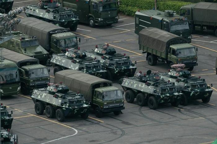 Thousands of Chinese military personnel waving red flags paraded at a sports stadium in Shenzhen, a Chinese city across the border from Hong Kong