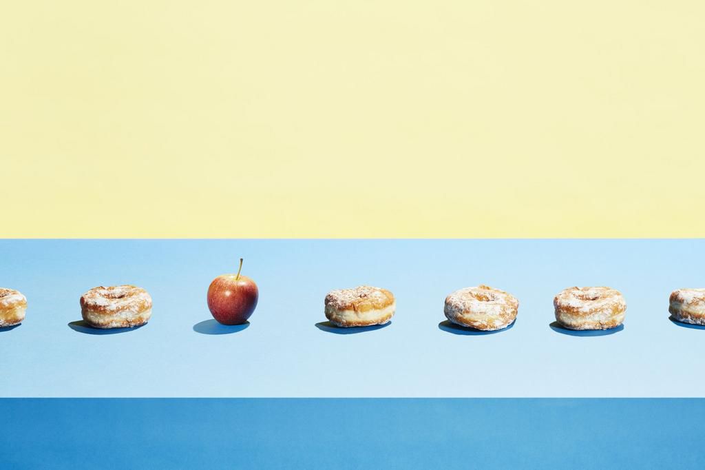 One apple in a row of donuts