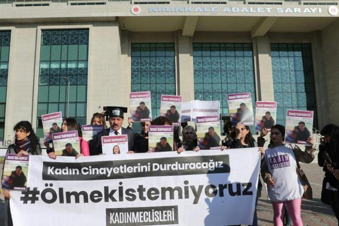 Women's rights activists gathered outside the courthouse, with a large banner reading "we don't want to die"