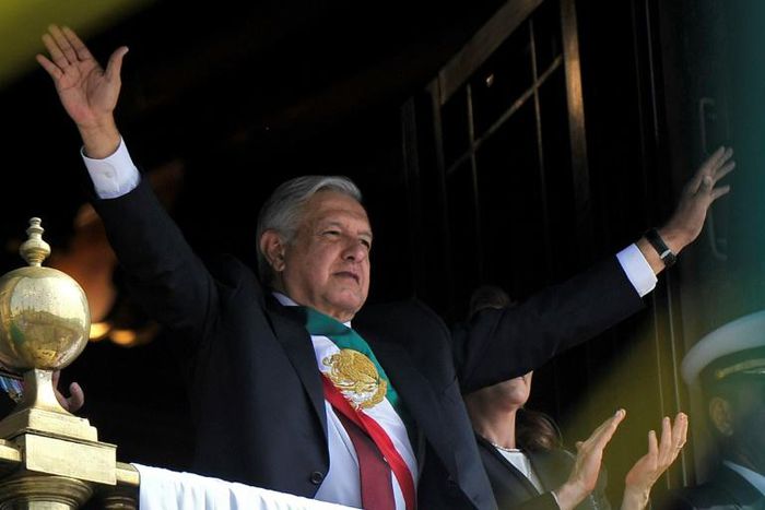 Mexican President Andres Manuel Lopez Obrador waves from the balcony of the National Palace during the anniversary of the Mexican Revolution in Mexico City on November 20