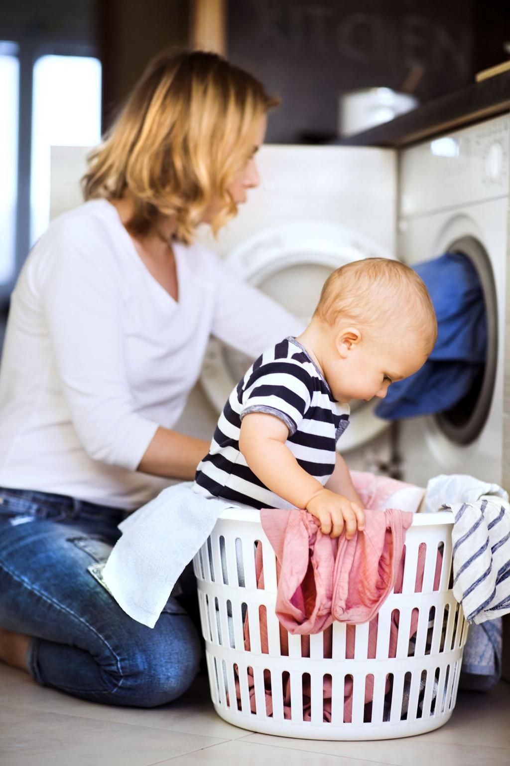 Young mother with a baby boy doing housework.