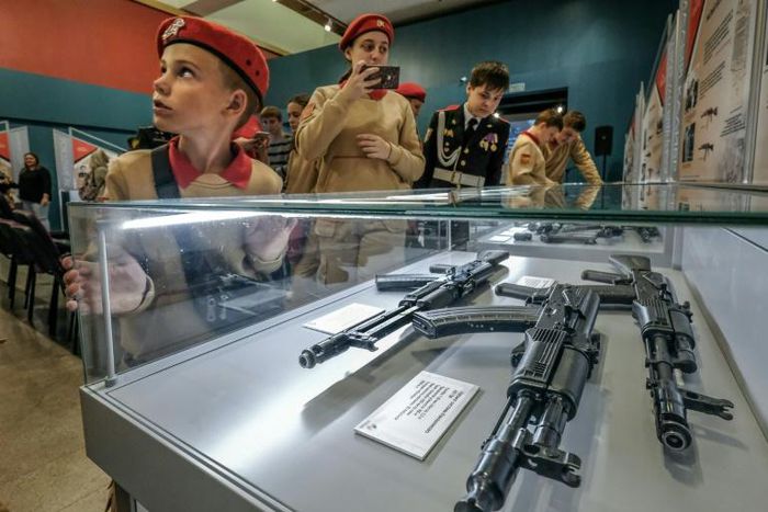 Members of Russia's Young Army patriotic movement get a close-up look at Russia's iconic Kalashnikov at a Moscow exhibition dedicated to their inventor