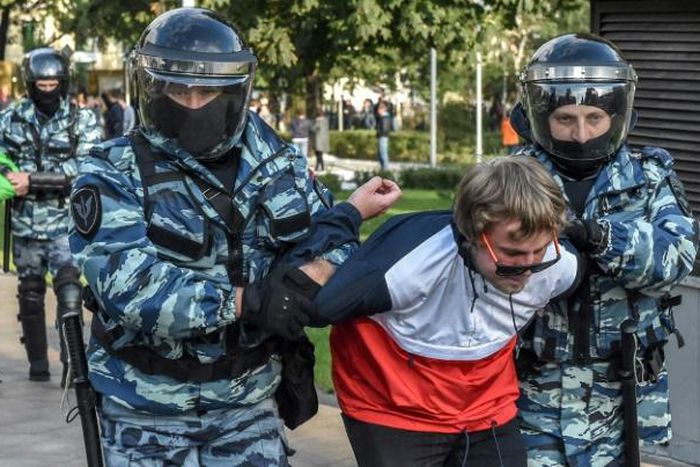 Russian National Guard officers detain protesters following a rally calling for fair elections in Moscow