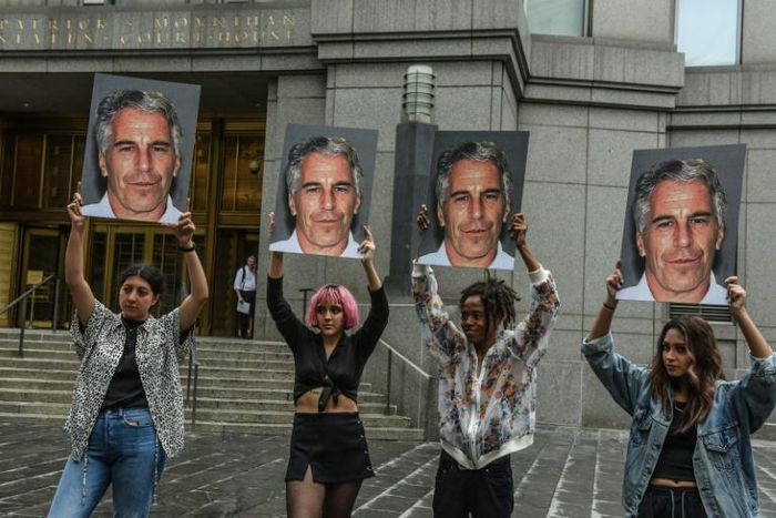 Protest group called "Hot Mess" hold up photos of Jeffrey Epstein in front of the Federal courthouse in New York City