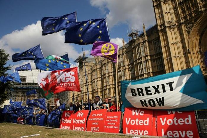Flags flutter as activists gather near the Houses of Parliament in central London on September 4, 2019 to demonstrate for and against Brexit
