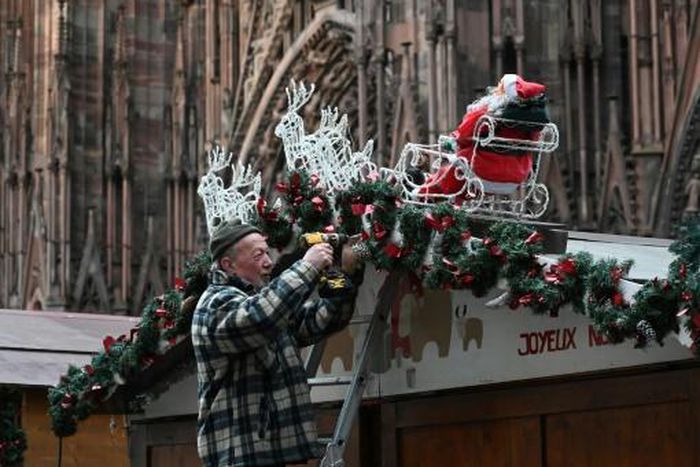 A worker installs decorations at the market, which will see a beefed up security presence this year