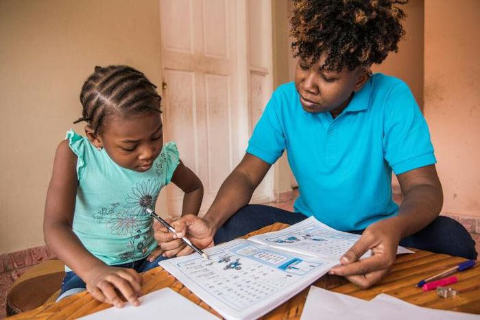 Edine Celestin (R) is homeschooling her five-year-old daughter Lyne-Renee as schools have been closed in Haiti's capital Port-au-Prince because of political unrest
