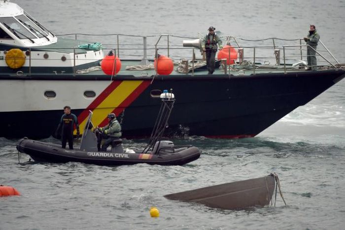 The prow of a submarine used to transport drugs illegally emerges as Spanish Guardia Civil's divers work to refloat it in northwestern Spain